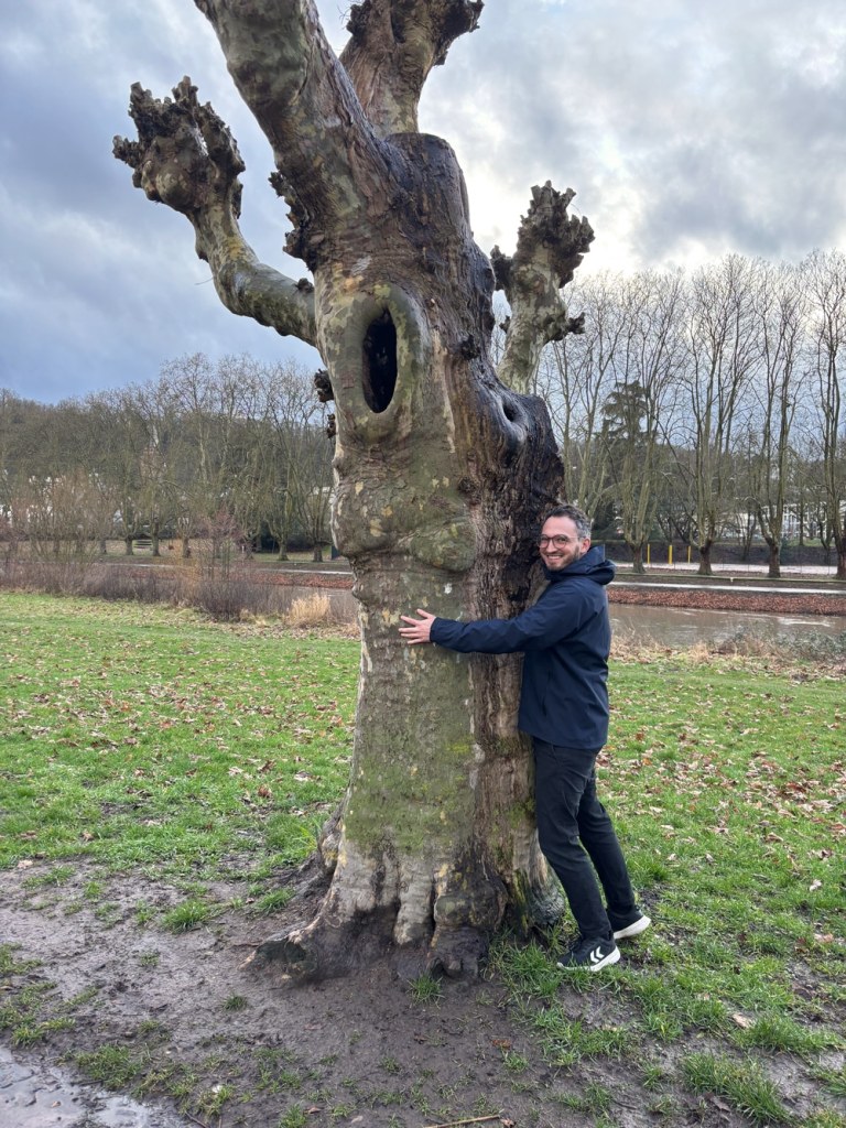 Cartoonist Jonathan Kunz hugging a tree